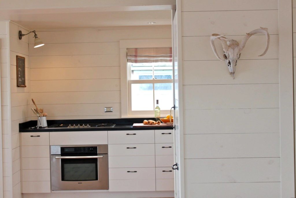 Белые панели из пластика на стене кухни частного дома