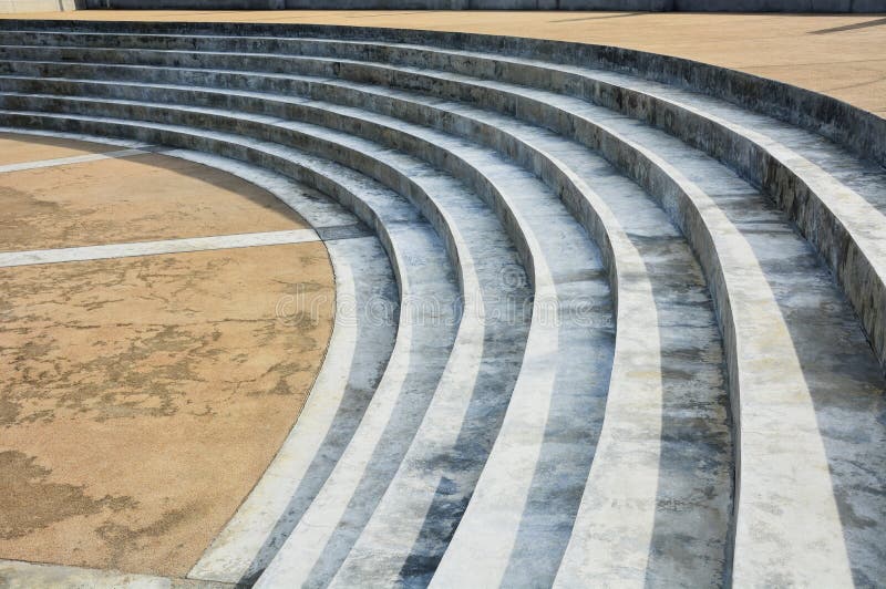 Abstract concrete stairs architecture details in semicircle shape with yellow pebble washed floor. Abstract concrete stairs architecture details in semicircle royalty free stock image