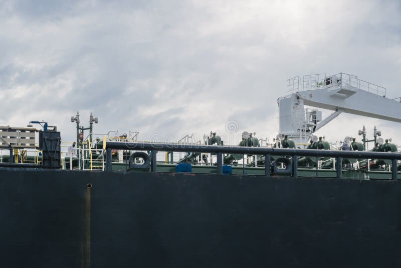 Abstract industrial or transport background illustrating shipping  and logistics. Featuring detail of large black and brown bulk ship board in sea port with stock photos