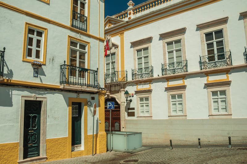 Alley with facades of old colorful houses. Elvas, Portugal - July 7, 2018. Empty alley with facades of old colorful houses at Elvas. A gracious star-shaped royalty free stock image