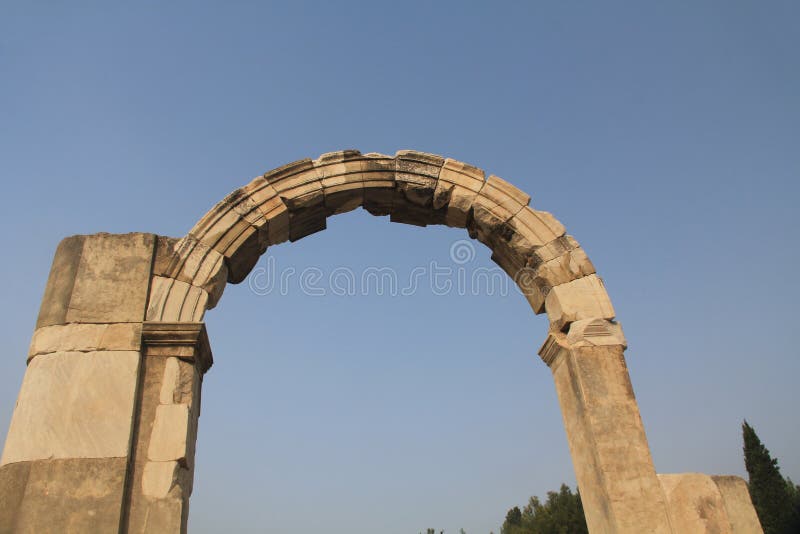 Archaeological Ruins of a Doorway Arch in Ephesus Turkey. Doorway arch along the Marble Road in the ancient city ruins of Ephesus, Turkey near Selcuk with blue royalty free stock photos