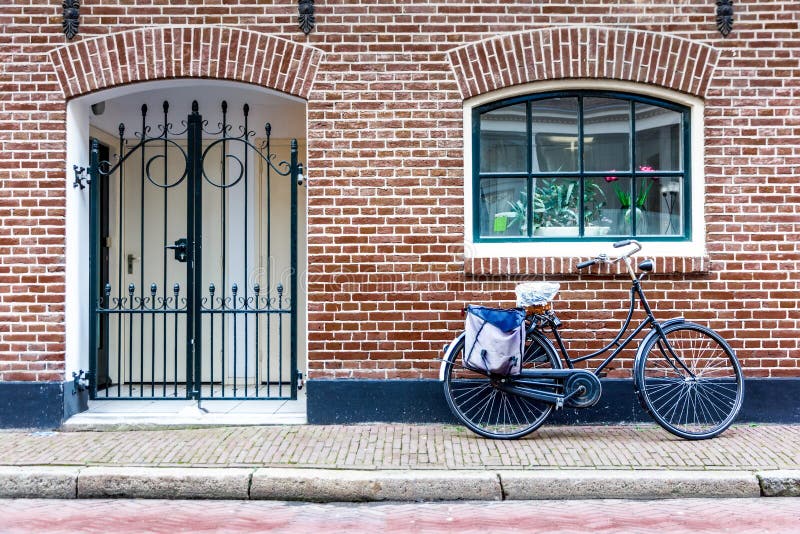 Bike at the front door. Dutch bicycle parking at a house front door against a brick wall royalty free stock photo