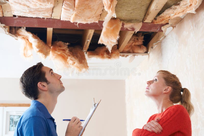 Builder And Client Inspecting Roof Damage stock photo