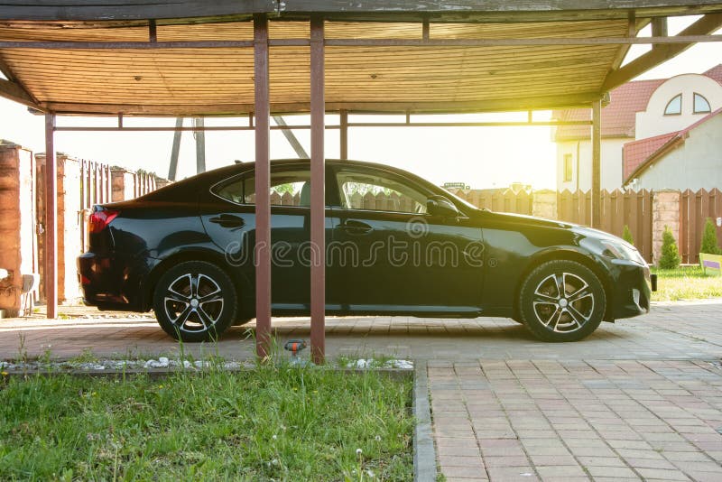 The car is under a canopy, an open garage, the territory of the will of the house. 2 royalty free stock photo