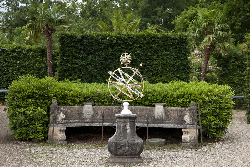 Classic sundial on stone plinth in beautiful formal garden of Twickel Estate, Hof van Twente. Beautiful forged sundial on ornate old stone plinth in the formal stock photo