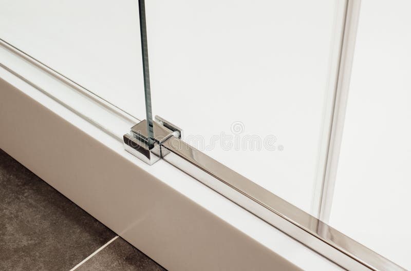 Close to lower metal fastening of the sliding glass door into the shower cabin. View in the interior royalty free stock photography