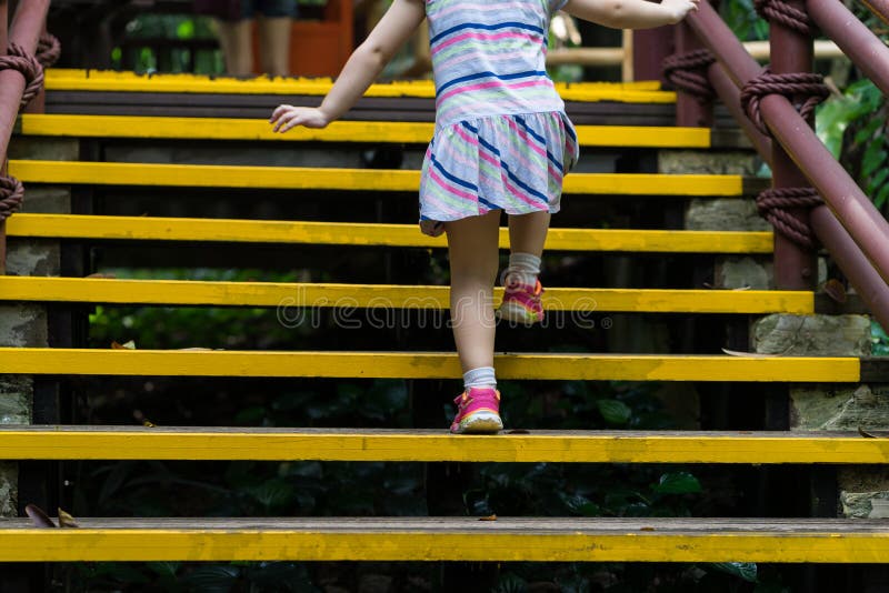 Closed up little girl climbing up stairs outdoors royalty free stock photo