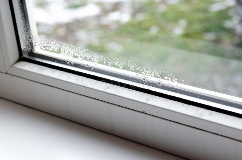 Drops of condensate and black mold on a white plastic window. stock photography