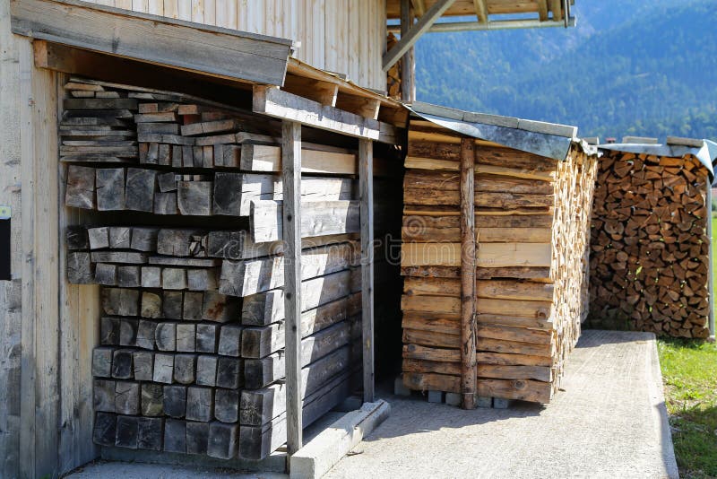 Dry wood piled under a canopy near the house.  royalty free stock images