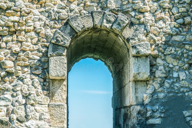 Entrance doorway in the stone wall, arch for entrance and exit in the ruins of the old city. Against the blue sky royalty free stock images