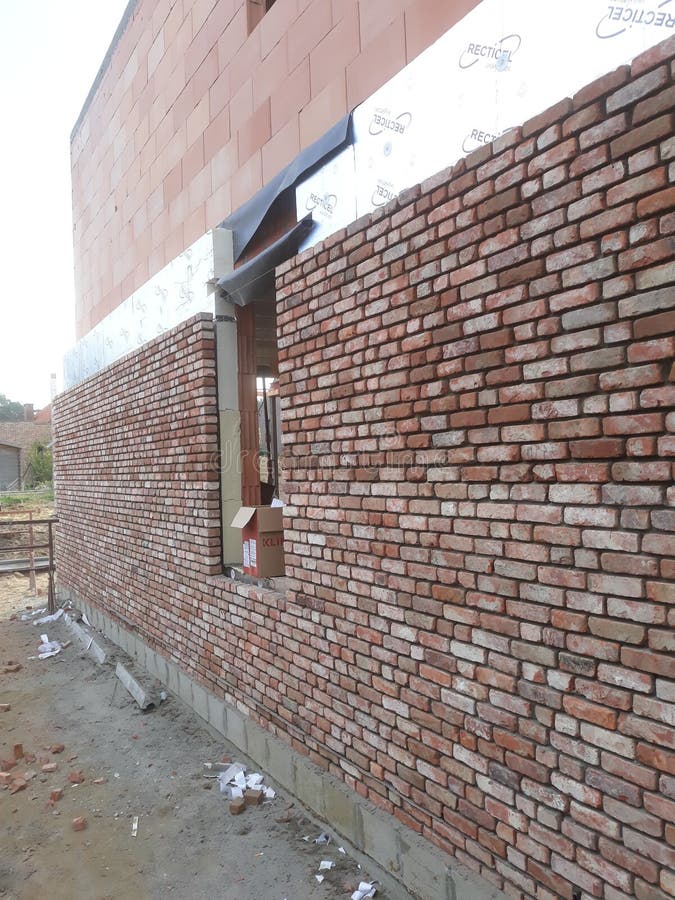 Finishing the facade of a private house under the brick stock photo