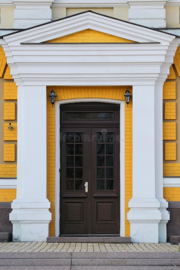 Front door. Elegant brown front door on the yellow wall royalty free stock photos