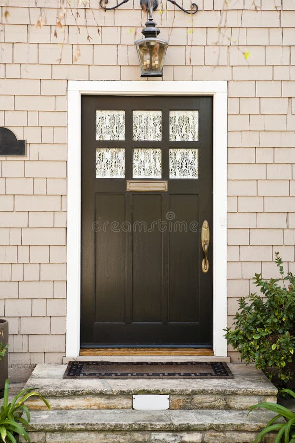Front Door of a Home. View of a classic front door with an overhead light and view of the front steps. Vertical shot stock image