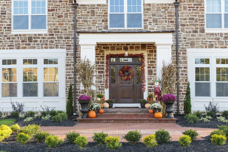 Front door, horizontal view of front door with seasonal decor. Seasonal front view of front door front yards house with brick exterior stock image