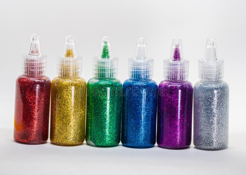 Glitter glue bottles. Colorful bottles of glitter glue, isolated on white background royalty free stock photography