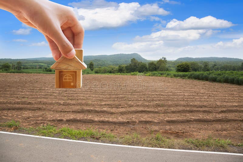 House symbol with location pin and Empty dry cracked swamp reclamation soil. Land plot for housing construction project with and beautiful blue sky with fresh royalty free stock photography