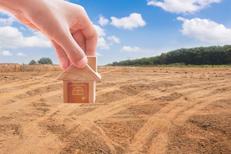 House symbol with location pin and Empty dry cracked swamp reclamation soil. Land plot for housing construction project with and beautiful blue sky with fresh stock photos