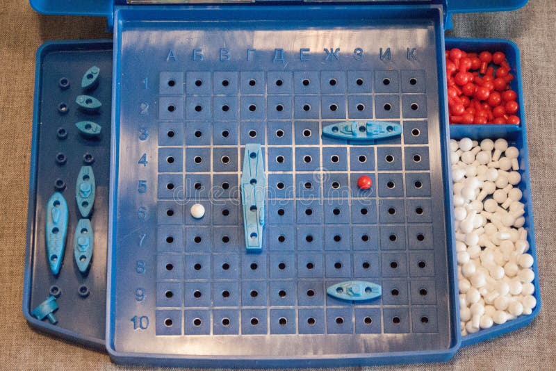 Image of the board game sea battle with the field on which ships are located and containers for chips of red and white color.  stock image
