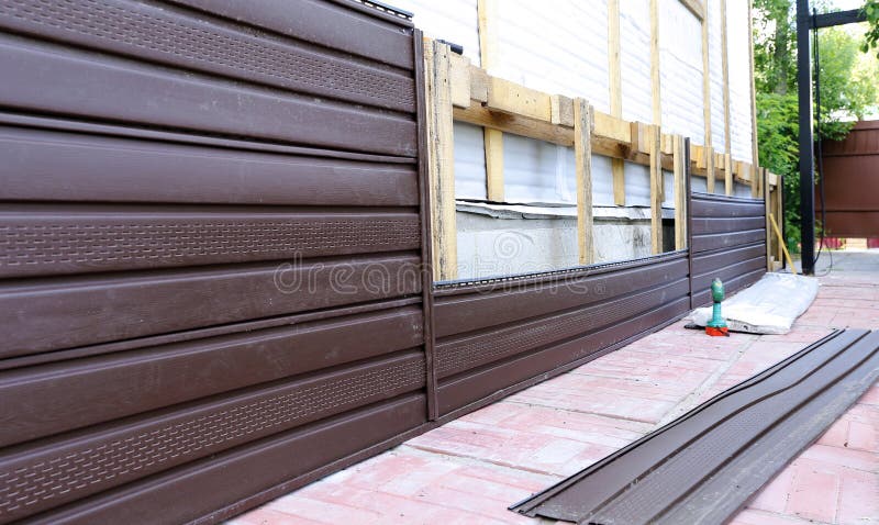 Installation of brown plastic siding on the facade stock photo