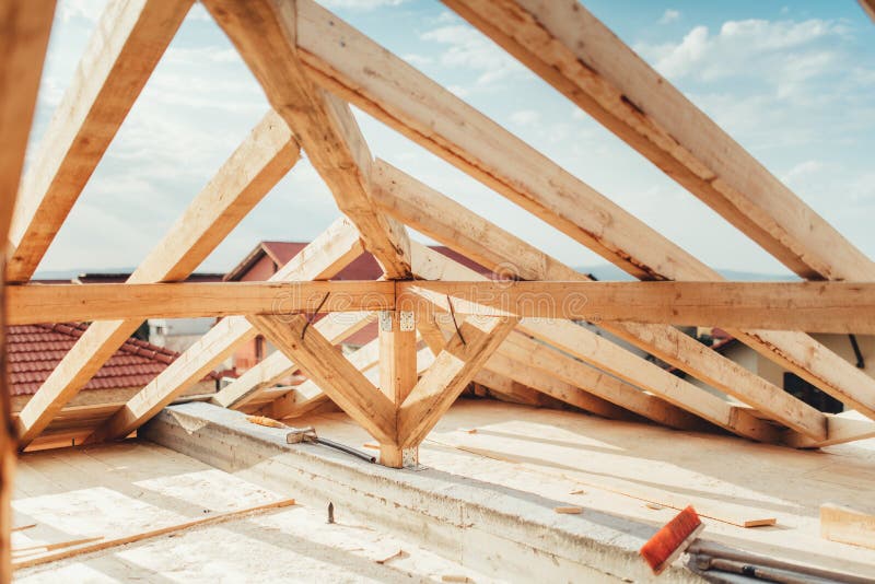 Installation of wooden beams at house construction site. Building details with wood, timber and iron holders royalty free stock image