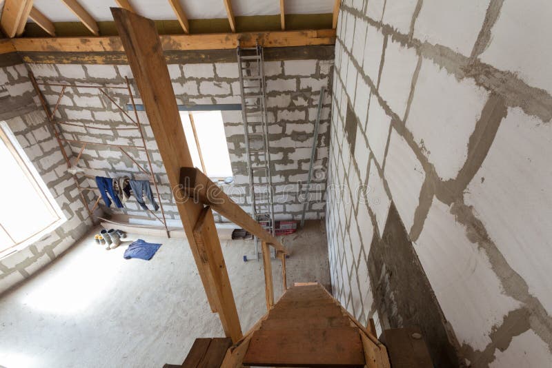 Interior of apartment during under renovation, remodeling and construction wooden stairs to the first floor and workers clothes. stock photography