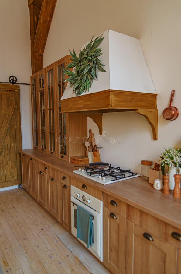 The interior of the kitchen in a rustic style, Scandinavian style. Wooden facades of cabinets. Nice sunny morning stock photography