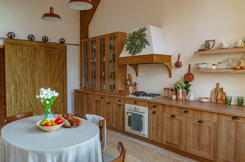 The interior of the kitchen in a rustic style, Scandinavian style. Wooden facades of cabinets. Nice sunny morning stock photography