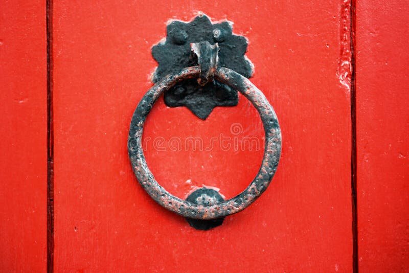 Iron antique ring handle on a red wooden door. royalty free stock photography