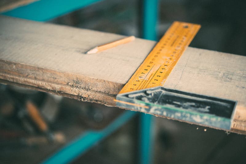 Length measurement using a metal ruler-corner on a wooden Board,carpentry.  stock photo