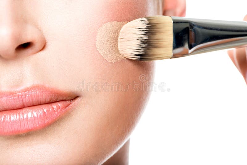 Makeup artist applying liquid tonal foundation on the face royalty free stock image