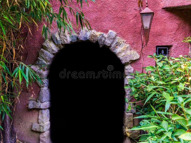 Medieval looking arch doorway with a lantern, castle architecture, dark door opening in a wall royalty free stock photos