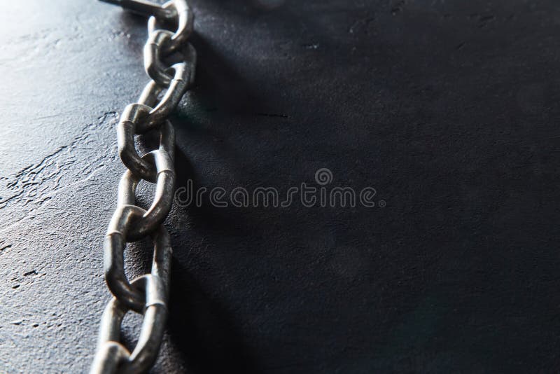Metal chain on black textured background. Connected steel links for fastening or securing objects, empty place for text.  royalty free stock photos