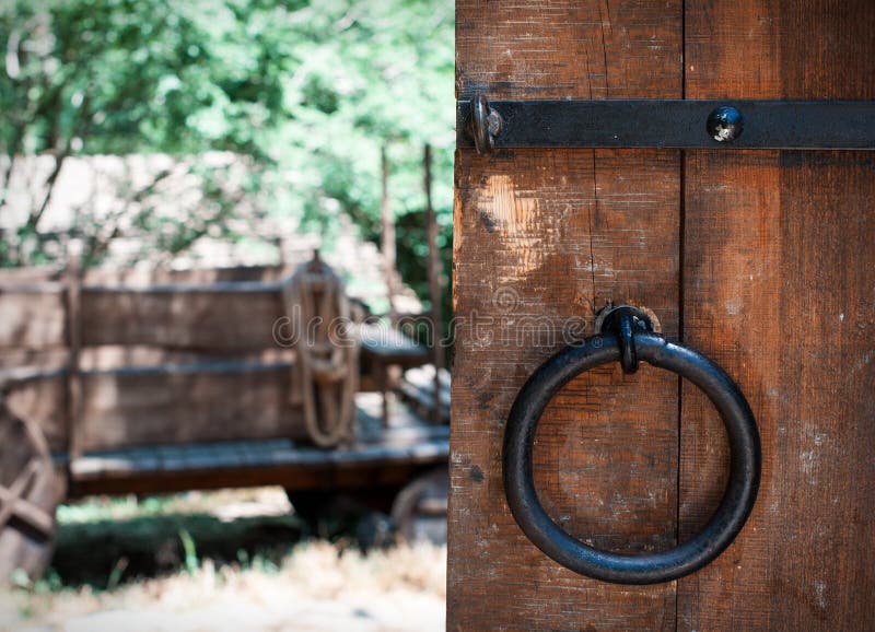Door handle-beater in the form of a ring on the old wooden gate stock images