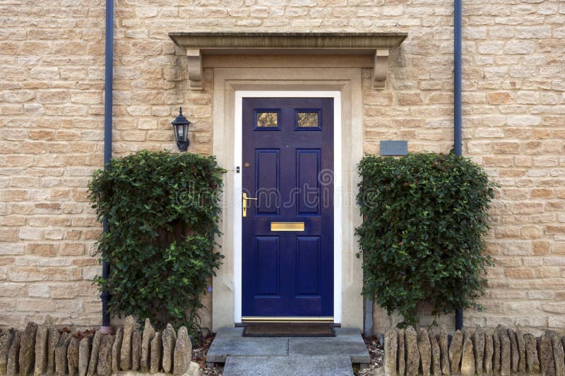 Front door. Modern blue painted front door flanked by shrubs stock images
