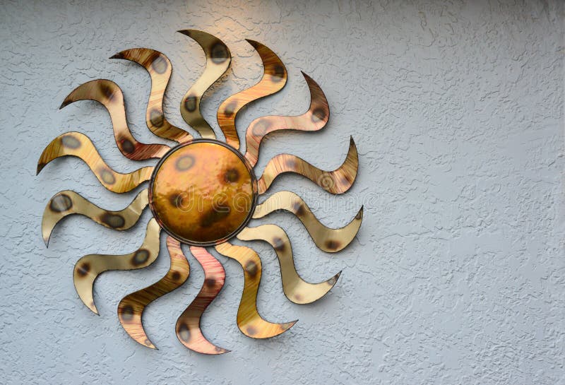 NEW MEXICO, USA - NOVEMBER 22, 2019: copper decoration in the form of the sun on a stone wall, New Mexico.  stock photography