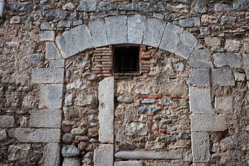 Old Stone Wall With Inbuild Arch. Medieval stone wall with inbuild arch and small window stock photos