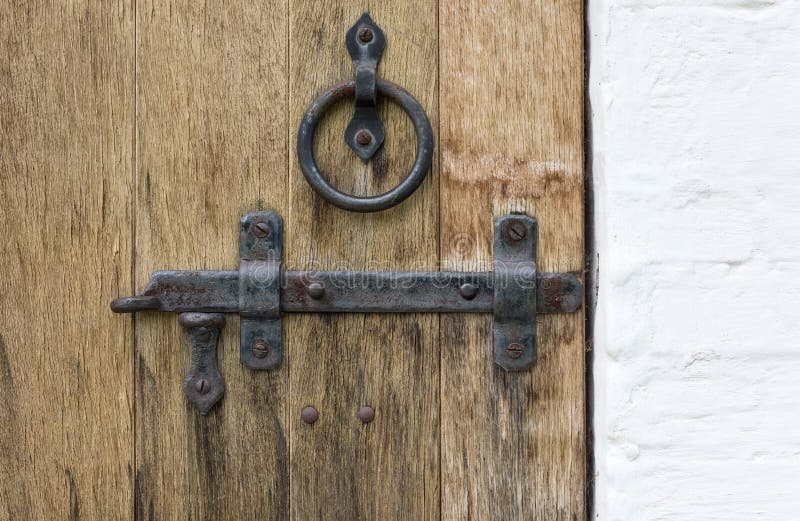Old wooden door with wrought iron latch and handle in the form of a ring stock photos
