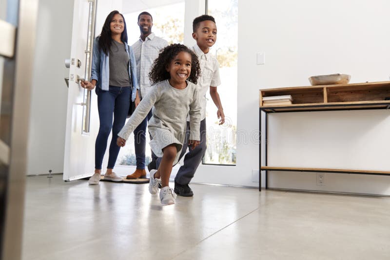 Parents And Children Returning Home Opening Front Door And Running Inside royalty free stock photo