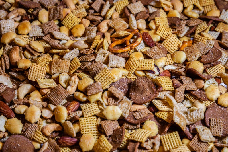 Party mix right out of the oven various crunchy bites. Including cereal, assorted nuts, pretzels and crackers of various sizes and shapes stock photo