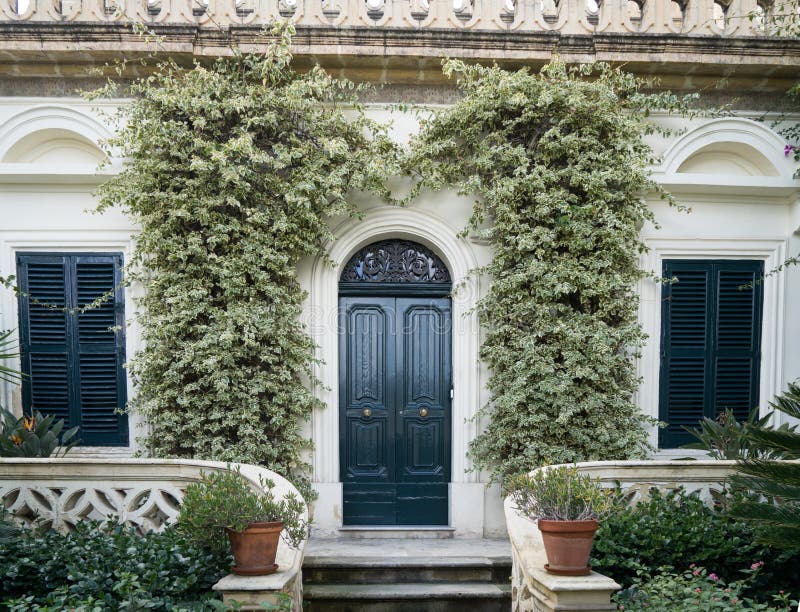 Rustic facade of a building. Double wooden door and windows with arcs. Facade of a building with windows royalty free stock photo