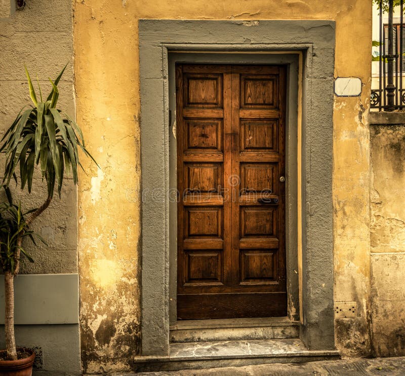 Rustic wooden door and grunge facade in Florence. Italy royalty free stock image