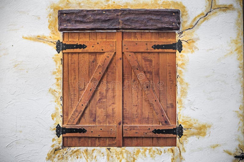 Rustic wooden window closed on white facade. Old fashioned wooden window closed on white rustic facade stock photography