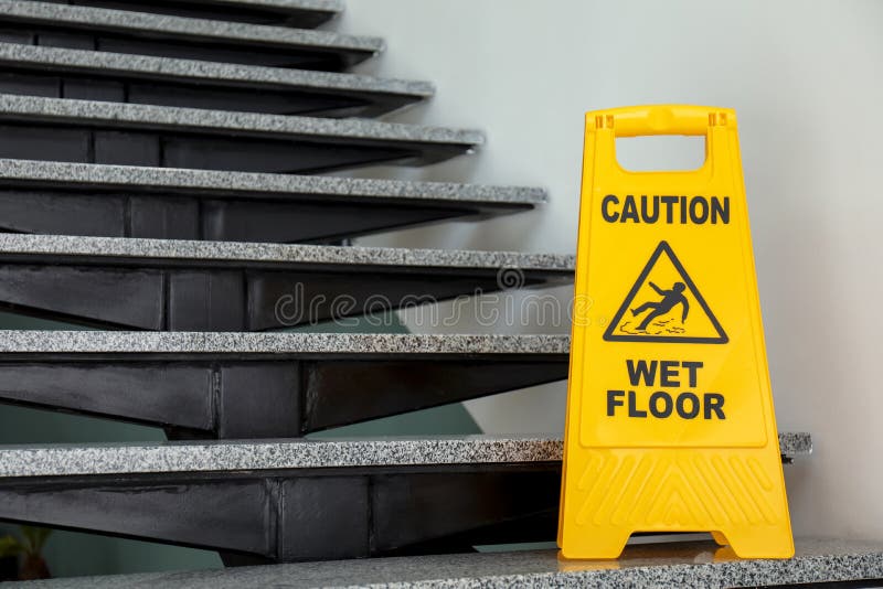Safety sign with phrase Caution wet floor on stairs. Cleaning service stock images