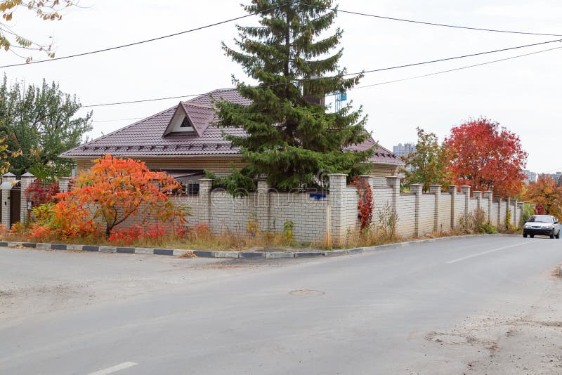 Saratov, Russia - 05/10/2019: Autumn city landscape, a residential building by the road behind a fence, a brick cottage with a stock photography