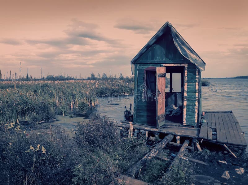 Scary old terrible abandoned hut, wooden creepy house on mysterious empty uninhabited swamp with dead trees and. Monochrome natural background of mistical royalty free stock photos