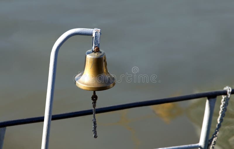 The ships copper bell on board. The copper bell on board. The ships bell on a background of calm river water. Horizontal photo stock photo