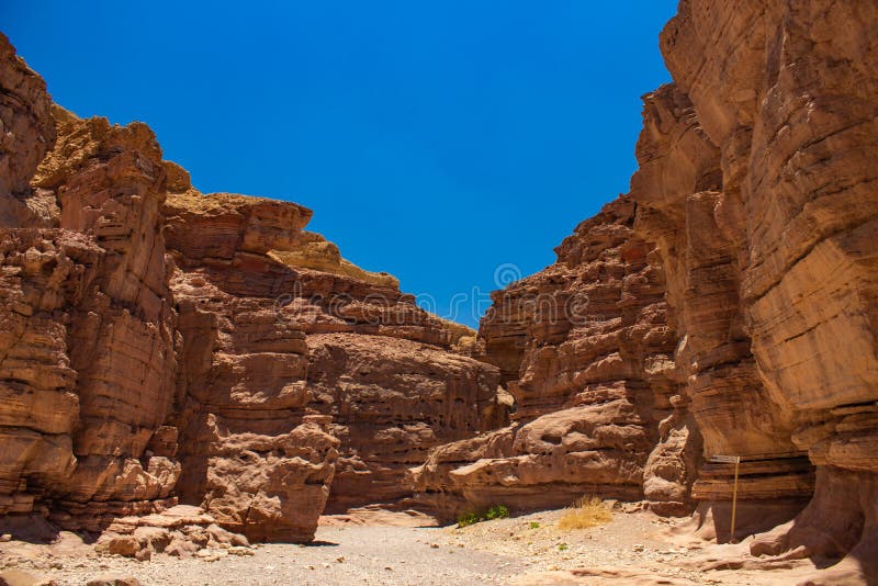 Soft focus desert sand stone canyon rocks passage trail between walls foreshortening from below on vivid blue sky background stock photography