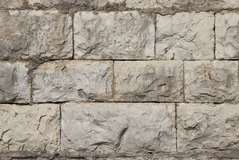 Stone natural wall in blocks. The texture of the stone block-lined wall of natural stone. Stone natural wall in blocks. The texture of the stone block-lined wall stock photography