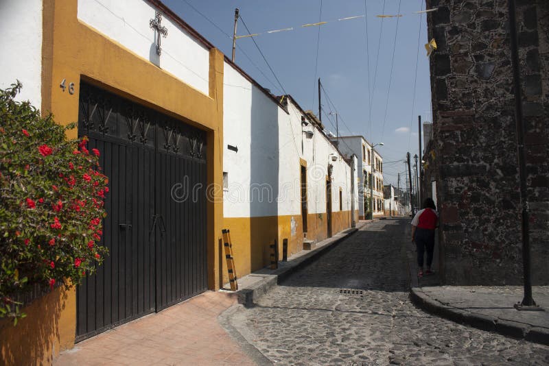 Alleys of Mexico City between white houses and cobbled streets with two-color facades. Streets in Mexico City considered a picturesque and rustic magical town stock photo