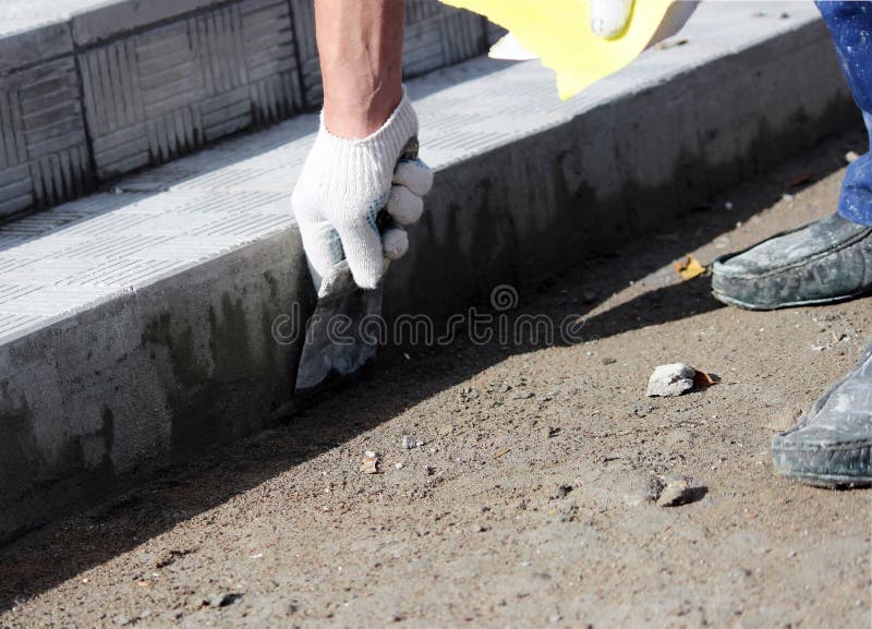 tiler processes the surface for laying the stone tiles on the steps in the repair of the office building. stock photos